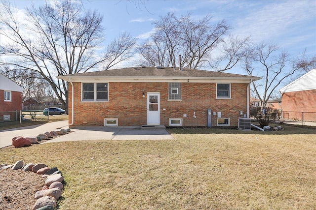 rear view of house featuring a patio, fence, a yard, central air condition unit, and brick siding