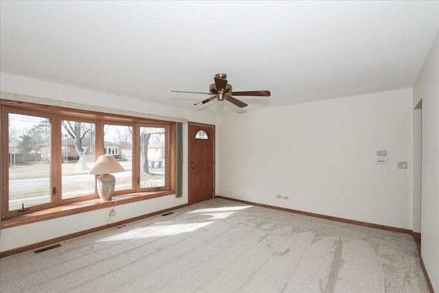 carpeted empty room featuring visible vents and baseboards