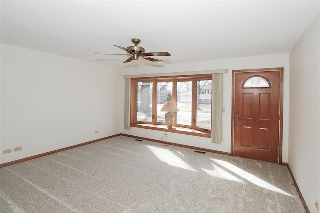 entryway with light carpet, visible vents, baseboards, and ceiling fan