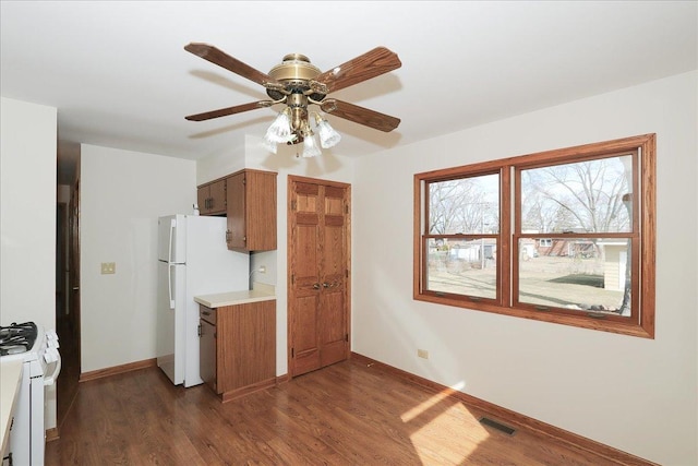 kitchen featuring white appliances, dark wood-type flooring, visible vents, baseboards, and light countertops