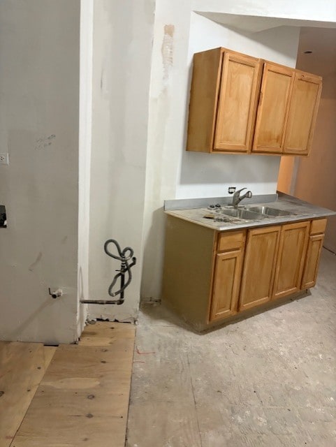 kitchen featuring light countertops, brown cabinets, and a sink