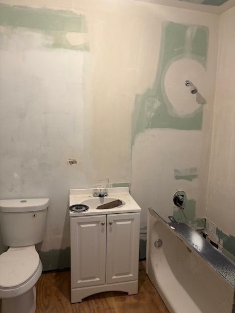 bathroom featuring toilet, wood finished floors, and vanity