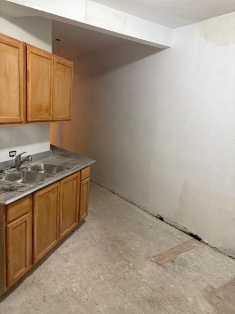 kitchen with brown cabinetry and a sink