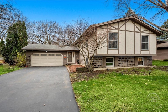 tudor-style house with an attached garage, a front lawn, aphalt driveway, and brick siding