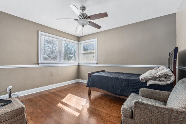 bedroom featuring ceiling fan, wood finished floors, and baseboards