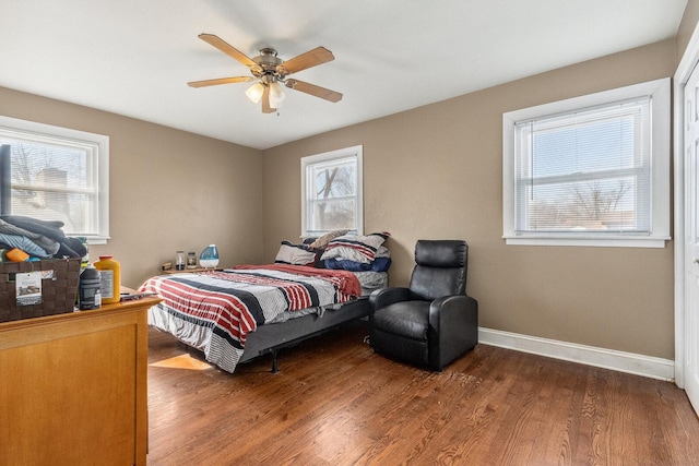 bedroom with ceiling fan, baseboards, and wood finished floors