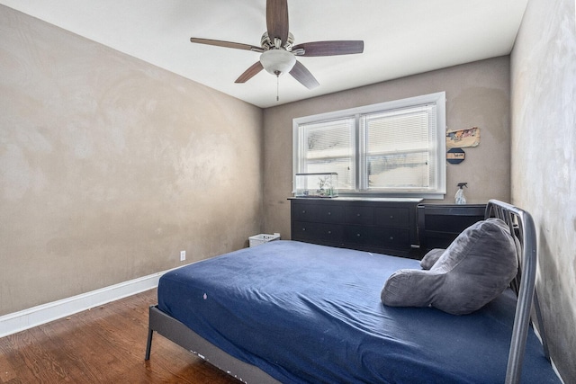 bedroom featuring a ceiling fan, baseboards, and wood finished floors