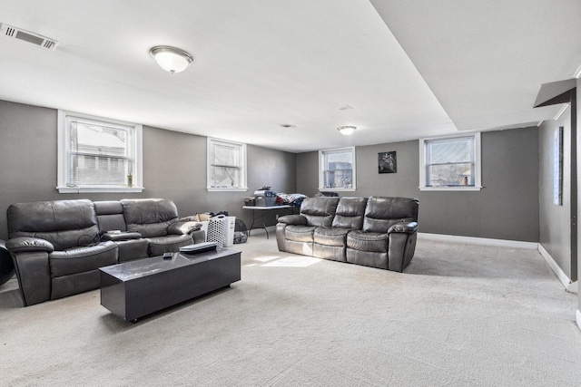 living area featuring baseboards, carpet, visible vents, and a healthy amount of sunlight