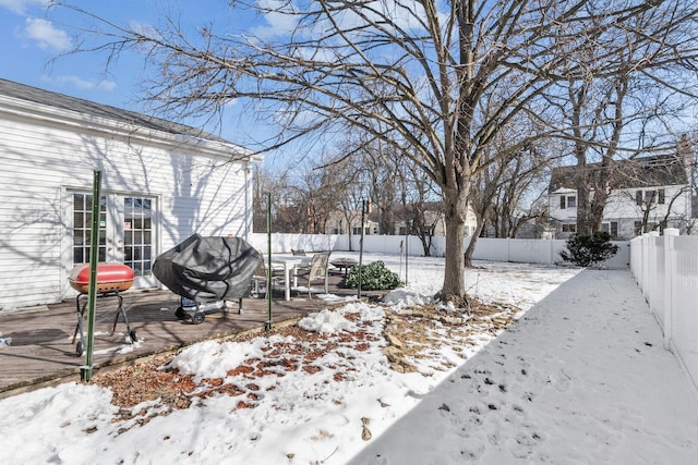 snowy yard with a fenced backyard