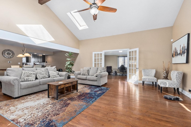 living room with a skylight, a ceiling fan, wood finished floors, french doors, and high vaulted ceiling