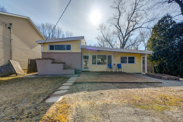 rear view of house featuring a deck and brick siding