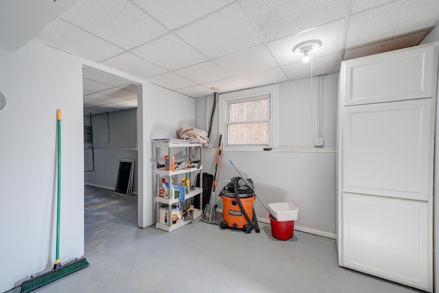 below grade area with a drop ceiling and baseboards