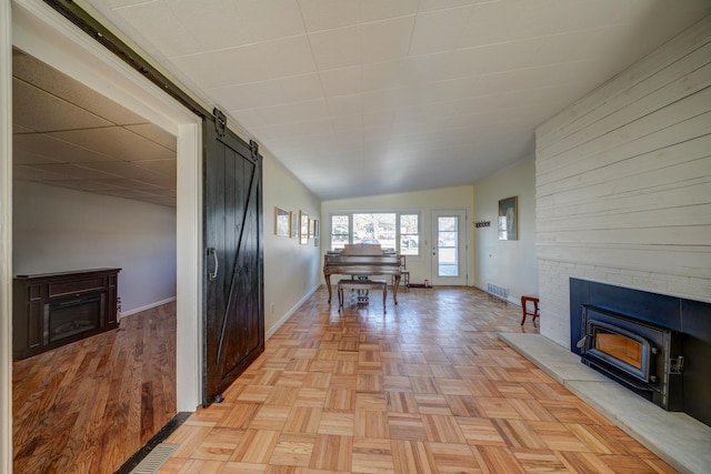 interior space with a barn door, a fireplace, and visible vents