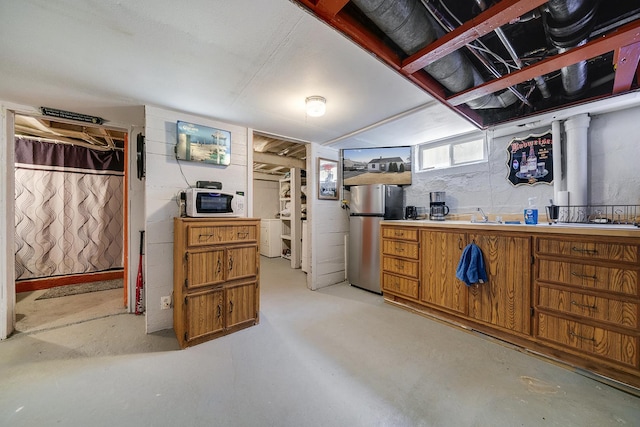 below grade area featuring a sink and freestanding refrigerator