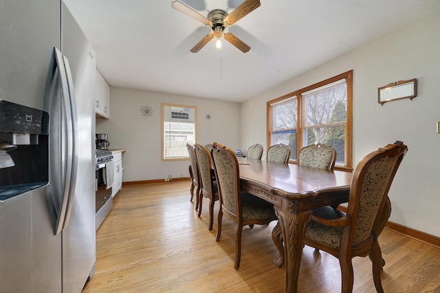 dining area featuring light wood finished floors, baseboards, and a ceiling fan