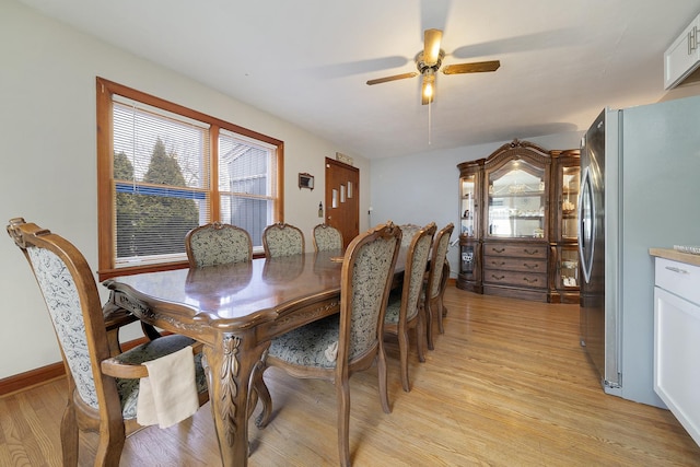 dining area featuring light wood-type flooring, ceiling fan, and baseboards