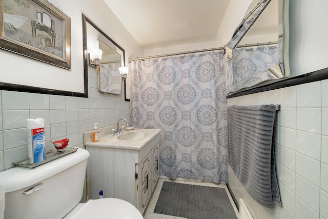 bathroom with toilet, curtained shower, tile walls, and vanity