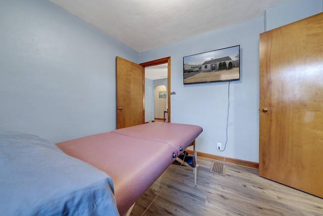 bedroom with wood finished floors and baseboards