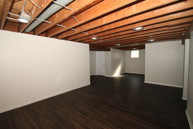 basement featuring baseboards and wood finished floors