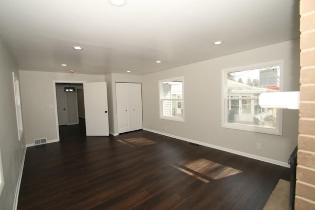 spare room with baseboards, visible vents, dark wood-style flooring, and recessed lighting