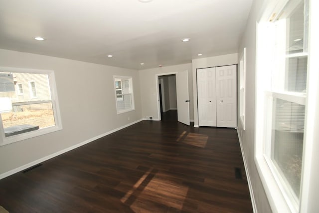 unfurnished bedroom featuring dark wood finished floors, recessed lighting, a closet, visible vents, and baseboards