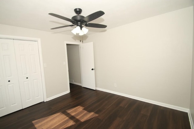 unfurnished bedroom featuring ceiling fan, baseboards, dark wood finished floors, and a closet