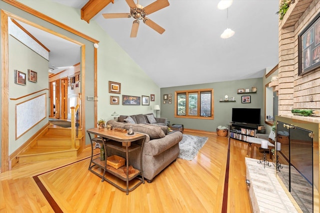 living room featuring high vaulted ceiling, wood finished floors, baseboards, stairway, and beamed ceiling