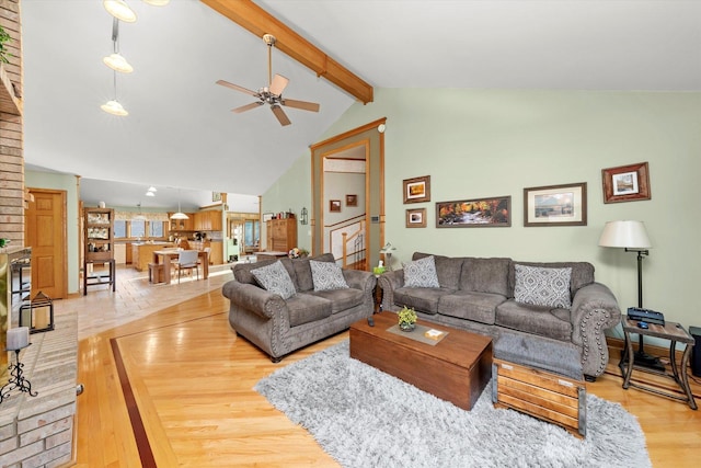 living room with light wood-style floors, beam ceiling, ceiling fan, and high vaulted ceiling