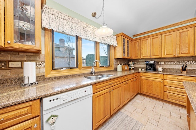 kitchen featuring dishwasher, backsplash, a sink, and decorative light fixtures