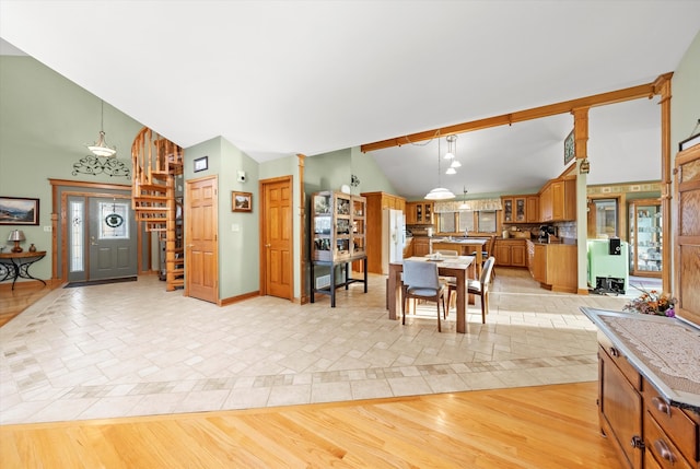 dining space with lofted ceiling, light wood-style flooring, and baseboards