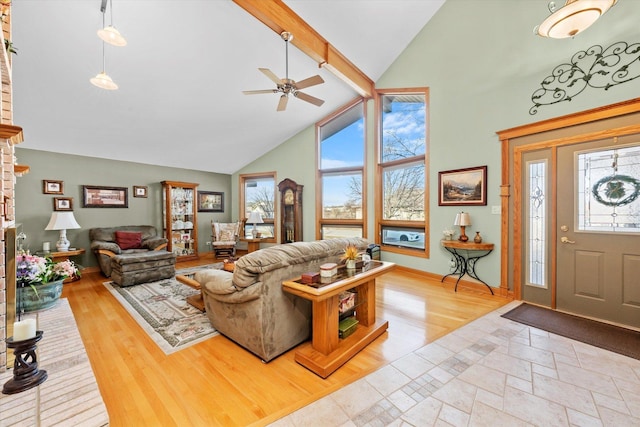 living room with high vaulted ceiling, a wealth of natural light, beamed ceiling, and wood finished floors