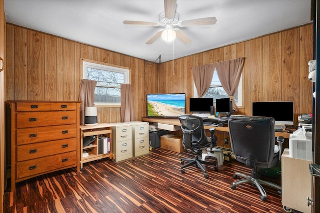 office space featuring dark wood-style floors, a ceiling fan, and wooden walls