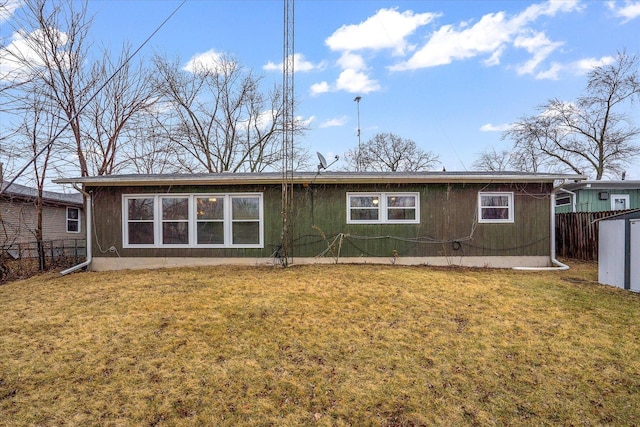 back of property featuring fence and a lawn