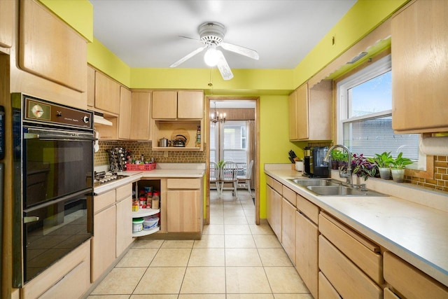 kitchen featuring light tile patterned floors, tasteful backsplash, dobule oven black, light brown cabinets, and a sink