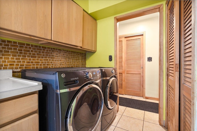 laundry room featuring cabinet space, light tile patterned floors, and separate washer and dryer