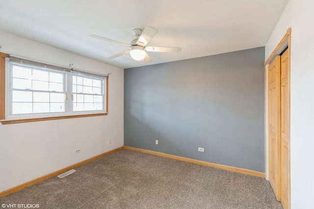 unfurnished bedroom with ceiling fan, carpet floors, visible vents, baseboards, and a closet