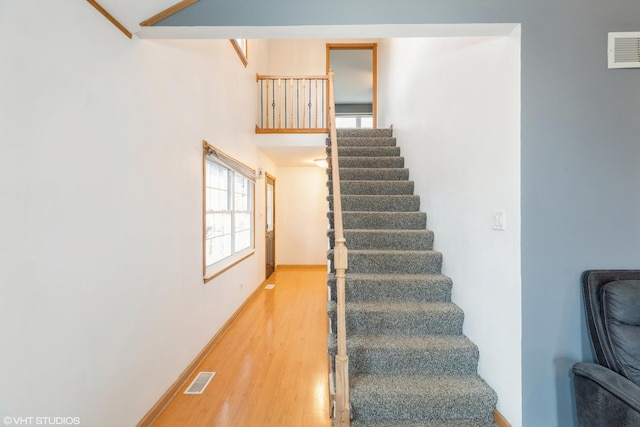 stairs featuring visible vents, baseboards, and wood finished floors