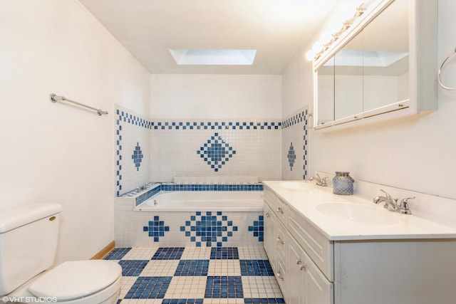 bathroom featuring tiled tub, a skylight, a sink, and toilet