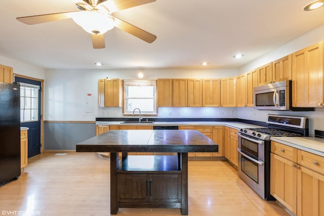 kitchen with recessed lighting, light wood-style flooring, appliances with stainless steel finishes, a ceiling fan, and a sink