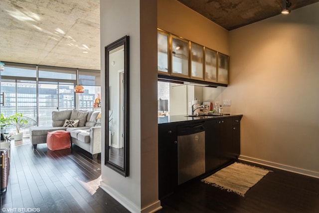 bar with dark wood-type flooring, a sink, baseboards, stainless steel dishwasher, and expansive windows