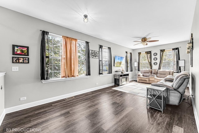 living room with baseboards, ceiling fan, wood finished floors, and a healthy amount of sunlight