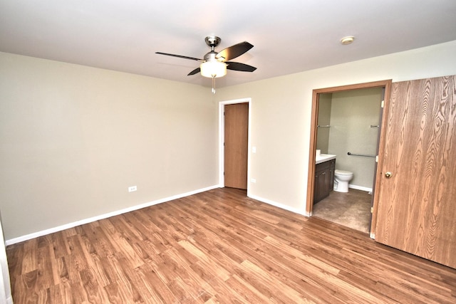 unfurnished bedroom with light wood-style flooring, baseboards, a ceiling fan, and ensuite bathroom