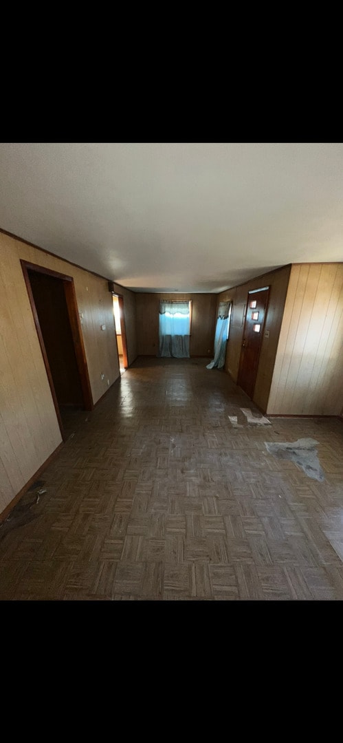 hallway featuring wooden walls