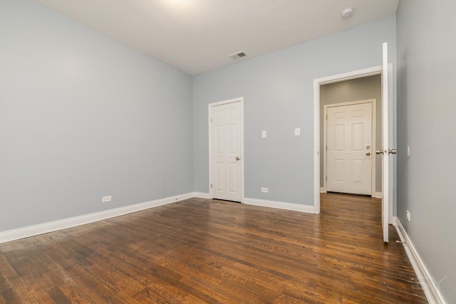 unfurnished bedroom featuring visible vents, baseboards, and wood finished floors