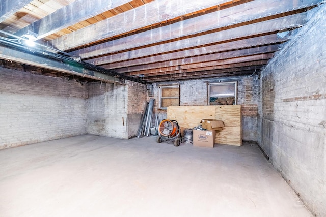 unfinished basement featuring brick wall