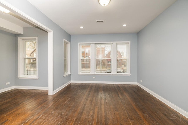 empty room featuring wood-type flooring, visible vents, baseboards, and recessed lighting