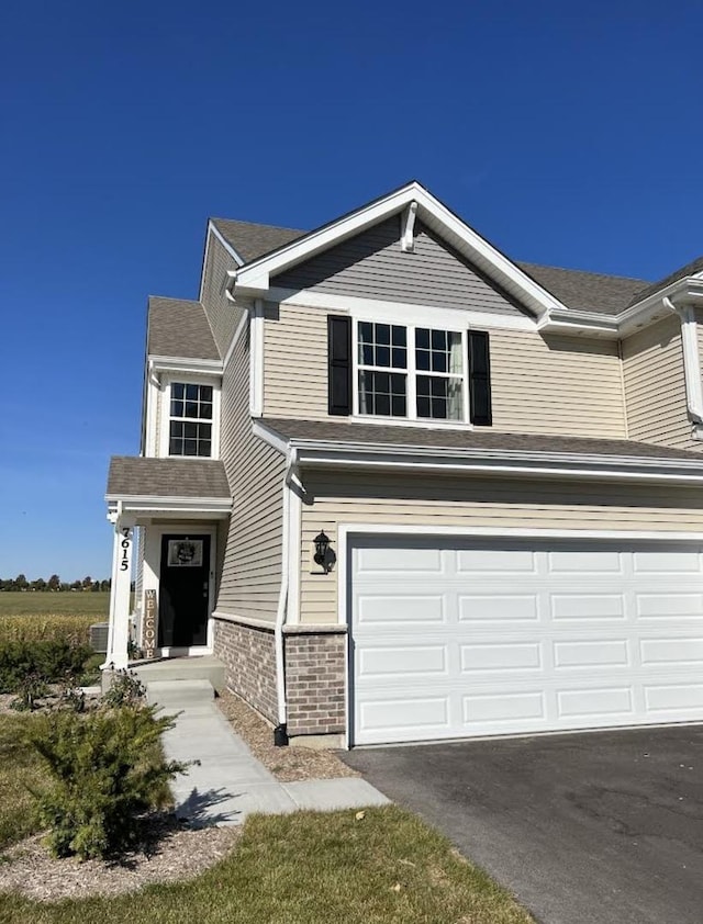 view of front of property with aphalt driveway, a garage, and brick siding