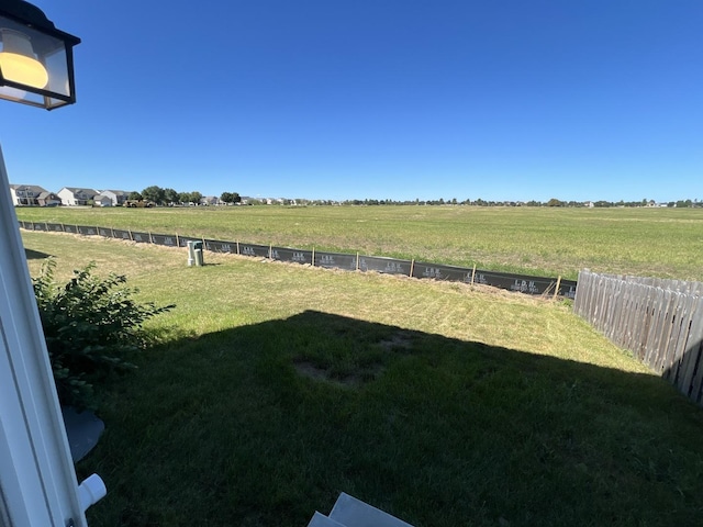 view of yard featuring a rural view and fence