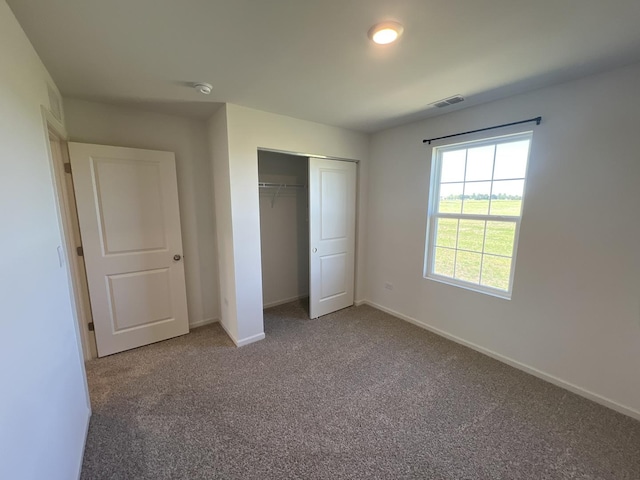 unfurnished bedroom featuring a closet, baseboards, carpet, and visible vents