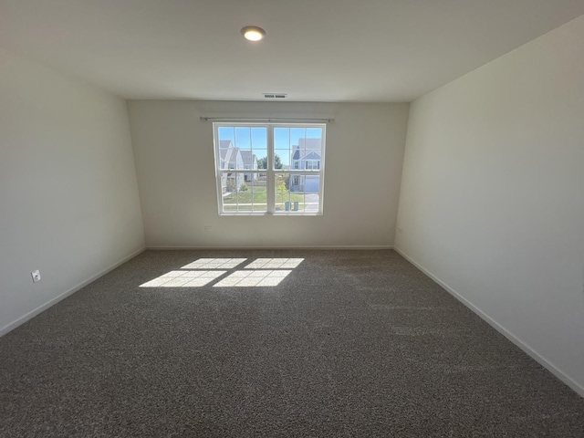 carpeted empty room featuring baseboards and visible vents